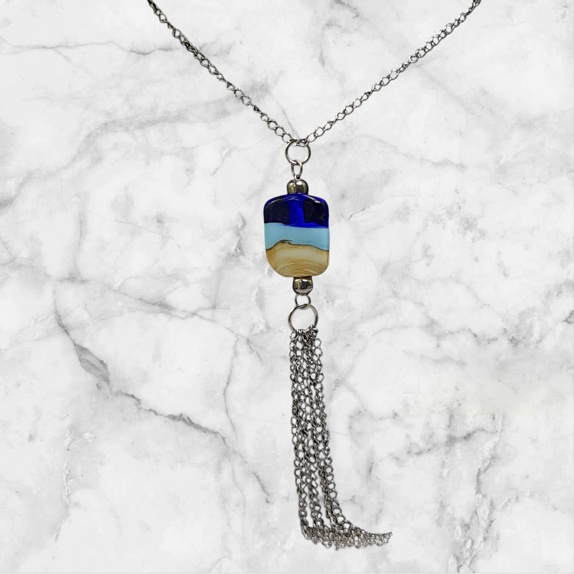 🌊🤍 Collier artisanal – Perle de verre beige, bleu clair et bleu profond inspirée du sable et de la mer